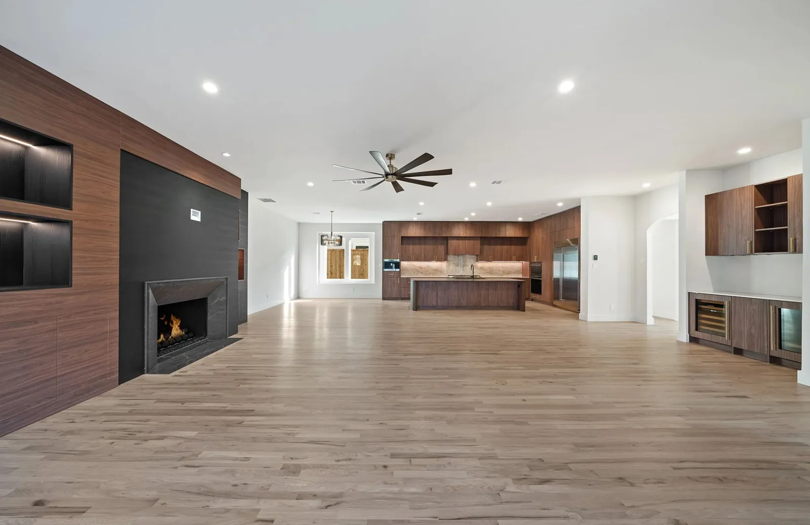Open-plan living room with a walnut media wall and fireplace