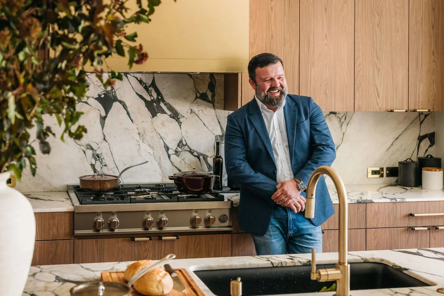 Martin, founder of Kabeenet, in a Kabeenet kitchen with walnut cabinetry and a marble backsplash